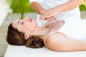 Calm woman receiving reiki treatment in the health spa